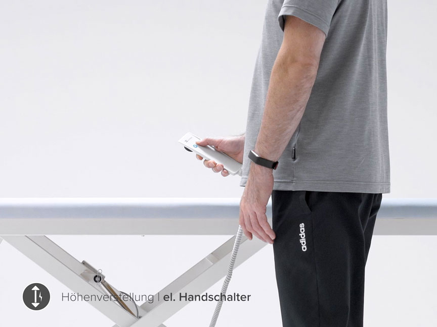 Eine Person verstellt die Höhe einer elektrischen Behandlungsliege mittels Handschalter