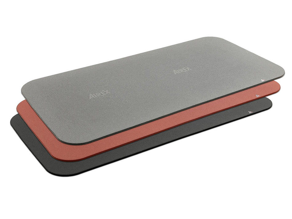 3 Gymnastikmatten versetzt aufeinandergelgt. EIne in ockerfarben, schwarz und grau der Marke AIREX.