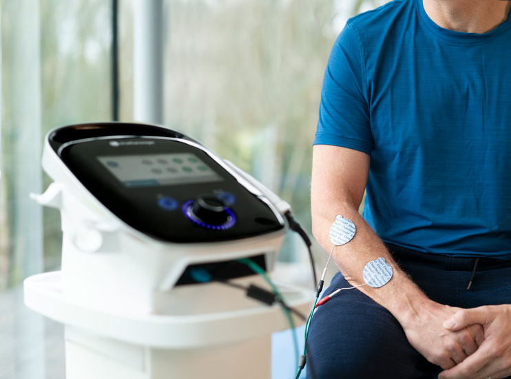 Ein Patient wird mit dem Elektro und Ultraschalltherapiegerät von Chattanooga behandelt